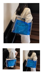 Close-up of blue transparent PVC tote bag with thick woven rope handles and inner pouch