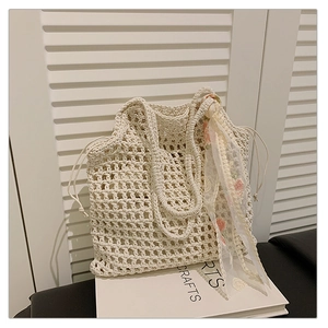 Detail of crochet tote bag featuring mesh design and delicate floral lace scarf detail