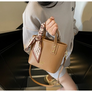 Detail of lychee pattern brown PU tote bag with decorative silk scarf on handle