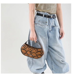 Close-up of snake skin printed mini handbag featuring Fashion Bags text on surface