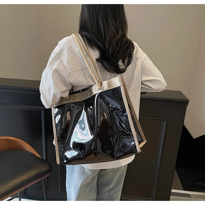 Detailansicht der großen Tragetasche mit glänzendem Lack-Finish und beigem Canvas-Rand