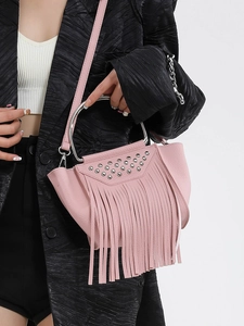 Borsa a secchiello rosa con frange e borchie argentate indossata su un abito nero