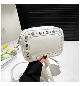 Dettaglio borsa fotografica bianca con borchie argentate e tracolla regolabile in pelle