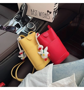 Detail of red and yellow lychee pattern phone bags with cute white goose charms in a car