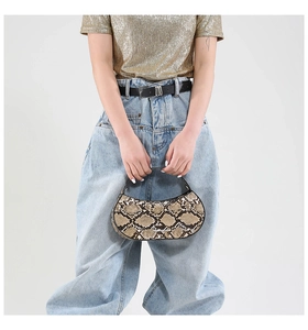 Detailed macro view of trendy python snake skin pattern on a half-moon shaped handbag