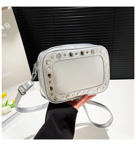 Dettaglio borsa fotografica argento con borchie metalliche e tracolla regolabile trendy