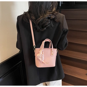 Detailed view of pink lychee pattern bucket bag featuring decorative scarf and gold hardware