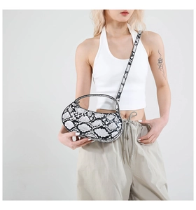 Detail showing the black and white python snake print on a stylish crescent moon underarm bag