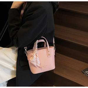 Detailed close-up of pink litchi grain bucket bag with silk scarf and ZSKE brand logo