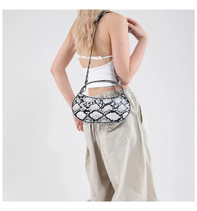 Detail shot of black and white snakeskin pattern texture on half-moon shoulder bag
