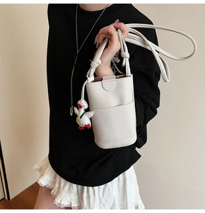 Détail du mini sac blanc en cuir à motif litchi avec un joli pendentif canard