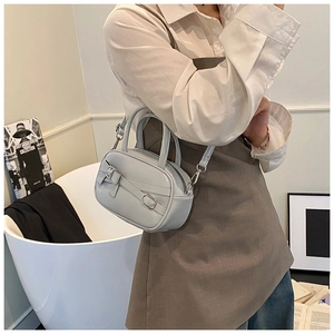 Detail of light blue PU leather bowling bag featuring decorative bow and buckle details