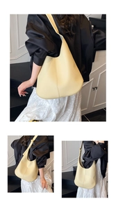 Detail of soft pale yellow lychee grain leather texture and central stitching of tote bag