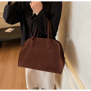 Detalle de bolso de ante marrón oscuro con textura mate para un estilo elegante