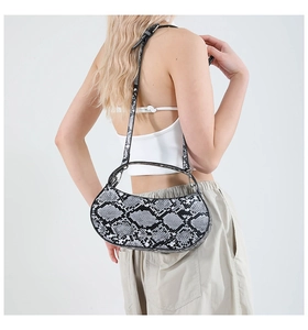 Detailed back view of a faux snake skin crossbody bag with adjustable strap and top handle