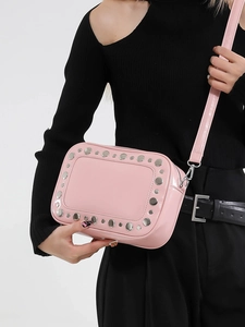 Borsa fotografica rosa con borchie argento e tracolla regolabile sul modello