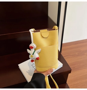 Détail du sac de téléphone jaune grainé avec un pendentif canard 3D mignon
