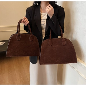 Detalle de bolsos tote grandes y pequeños en ante marrón mostrando textura mate y artesanía