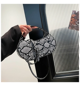 Detail of snake print moon bag showing texture, silver hardware and detachable strap