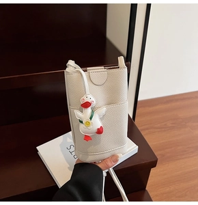 Détail de la pochette téléphone blanche à motif litchi avec pendentif canard et sangle