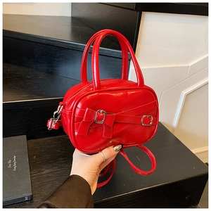 Detail of red patent leather bowling bag with silver buckle and leather bow decoration