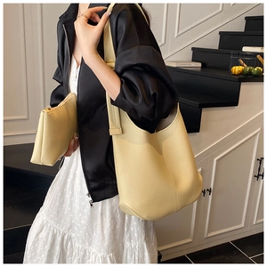 Detail of yellow lychee grain leather tote bag with matching zippered pouch