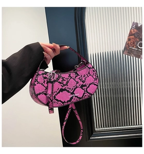Detail of pink snakeskin pattern moon bag with silver buckle and fashion typography