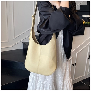 Detail of minimalist beige pebble leather tote with adjustable wide strap for women