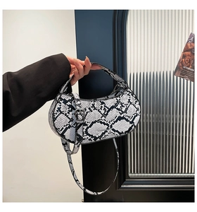 Detail of snake print mini bag with silver buckle and detachable shoulder strap