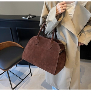 Primer plano del bolso tote de ante marrón café con asas dobles y una textura suave