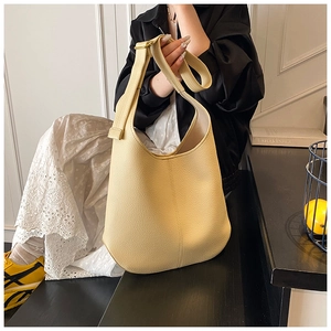 Close-up of the light yellow lychee pattern leather texture and wide shoulder strap