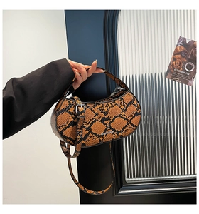 Detail of snake print crossbody bag with silver hardware and adjustable strap