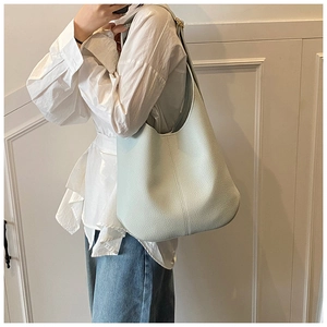 Detail of light blue lychee pattern leather hobo bag with wide strap and soft texture