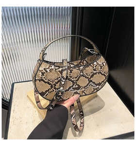 Close-up of python print handbag with adjustable shoulder strap and vintage texture