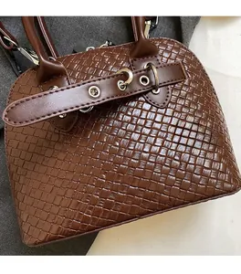 Detail of brown woven PU leather handbag with silver metallic hardware and texture