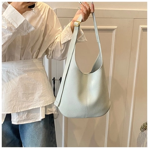Detail showing high-quality lychee grain leather and gold buckle on a mint blue hobo bag