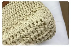 Close-up of natural beige straw weave texture with brown leather edging detail