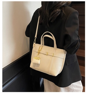 Litchi texture leather tote bag detail with golden chain mini accessory and strap