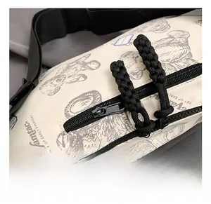 Detailansicht der beigen Umhängetasche mit Bärenprint und schwarzen Reißverschlüssen