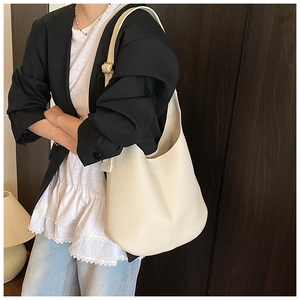 Close-up of cream white lychee grain leather texture and gold buckle on hobo bag