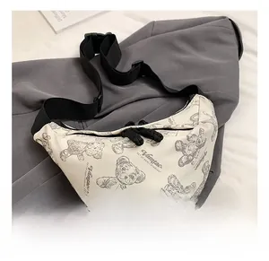 Detailaufnahme der weißen Umhängetasche mit Bärenprint und verstellbarem Nylonriemen