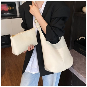 Detail view of the large off-white lychee grain leather tote bag with a small inner pouch