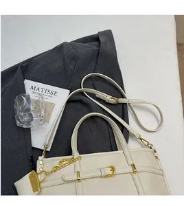Detail of lychee textured leather handbag with gold metal buckle and adjustable strap