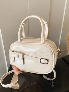 Chic beige mini bowling bag in glossy synthetic leather with elegant bow and metal buckles
