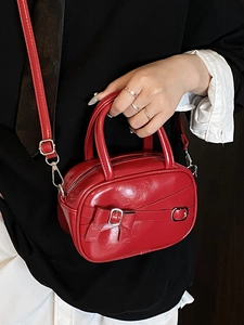 Chic red mini bowling bag with bow detail and silver buckles for women shown in hand