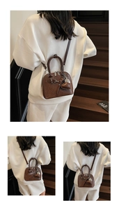 Detail of dark brown shell bag showing woven texture, heart pendant and silver hardware