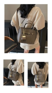 Detail showing litchi grain texture and decorative buckle on the khaki tote bag