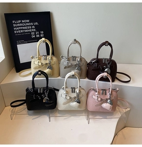 Detailed view of woven texture shell bags in six colors with heart charms and straps