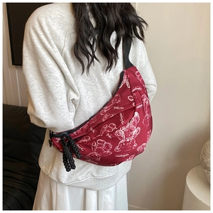 Detail der weinroten Crossbody-Tasche mit Bärenprint und gewebtem Reißverschlusszug