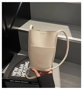 Close-up of white lychee textured PU leather phone bag with a convenient front pocket